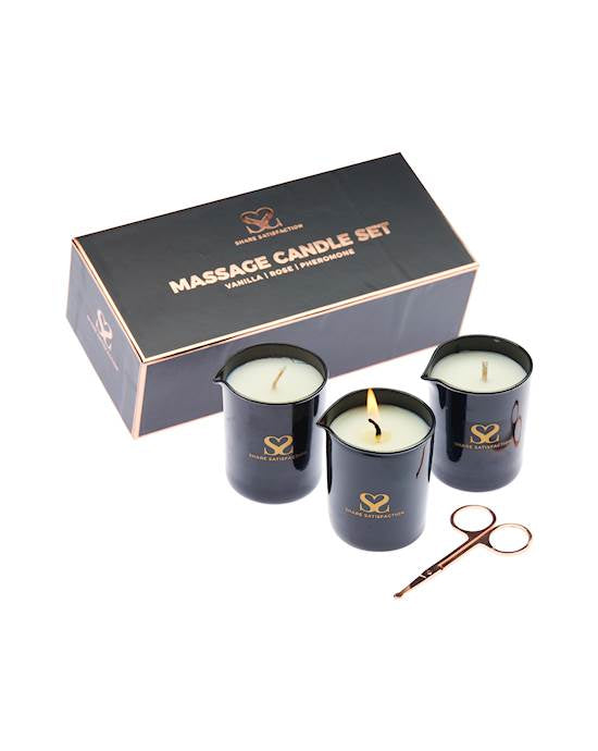 On a white background sits a rectangular cardboard box and in front of this are three candles and a small pair of scissors.