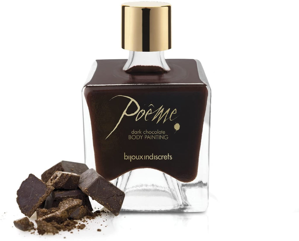 Clear bottle resembling a perfume bottle with a gold lid and gold writing with brown liquid ingredients and beside pieces of dark chocolate.
