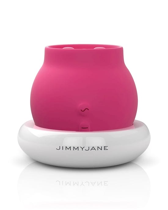 A rosy pink coloured rubber ball shaped object with a cut off top sits in a white docking station.