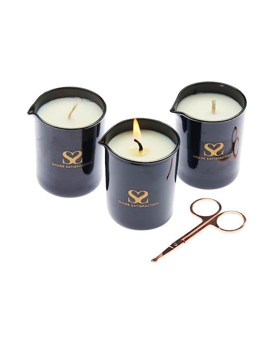 Three black cups with spouts containing candles. The candle in the centre is lit and there is a pair of scissors laying beside it.