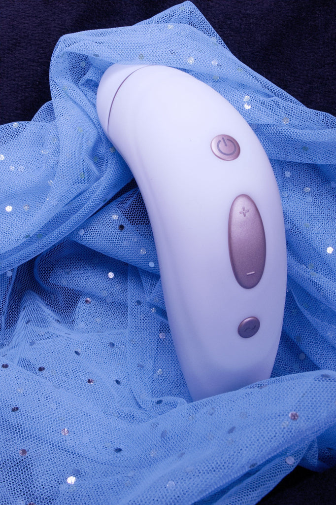White product standing upright displaying copper coloured power and speed buttons with a pale blue sparkly sheet in the background.